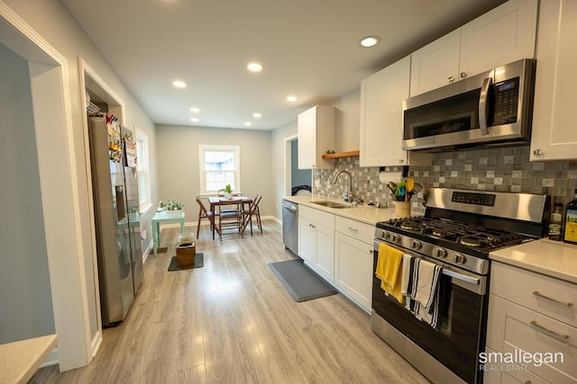 5161 Grand River Dr NE, Grand Rapids, MI 49525 - kitchen featuring appliances with stainless steel finishes, light countertops, tasteful backsplash, white cabinets, and recessed lighting