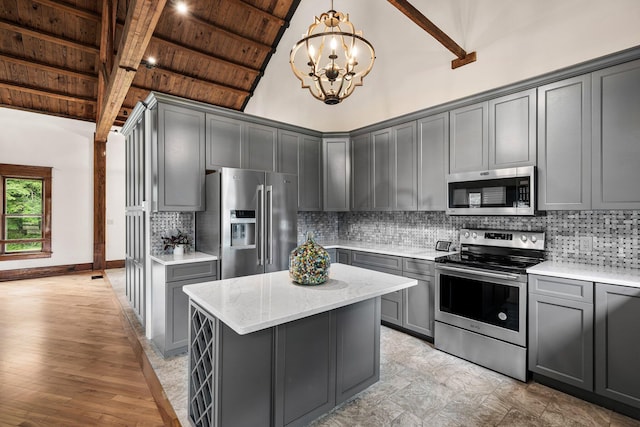 13060 Broadway Rd, Three Rivers, MI 49093 - kitchen featuring appliances with stainless steel finishes, gray cabinetry, a wooden ceiling with exposed beams, a chandelier, and light stone counters