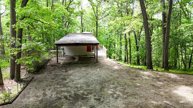4075 N Delhi Rd, Ann Arbor, MI 48103 - view of patio / terrace featuring driveway, a carport, and a forest view