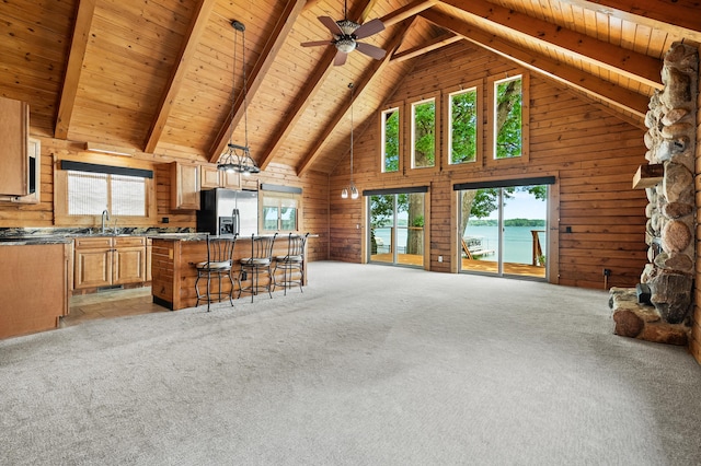 9715 Woodlawn Dr, Portage, MI 49002 - kitchen with stainless steel fridge with ice dispenser, high vaulted ceiling, open floor plan, a wood ceiling with exposed beams, and wooden walls