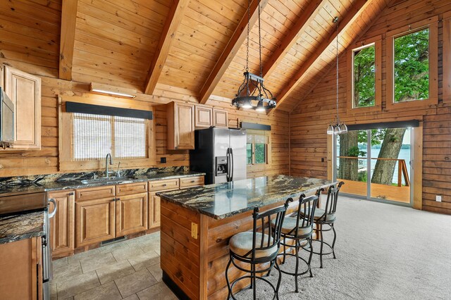 9715 Woodlawn Dr, Portage, MI 49002 - kitchen with stainless steel fridge, healthy amount of natural light, a wooden ceiling with exposed beams, wood walls, and a breakfast bar