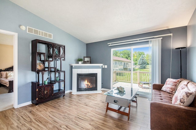 2663 Weatherby Hills Dr SE, Grand Rapids, MI 49546 - living room with wood finished floors, vaulted ceiling, and a fireplace