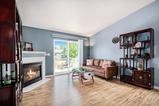 2663 Weatherby Hills Dr SE, Grand Rapids, MI 49546 - living area with light wood-type flooring, a tiled fireplace, and lofted ceiling
