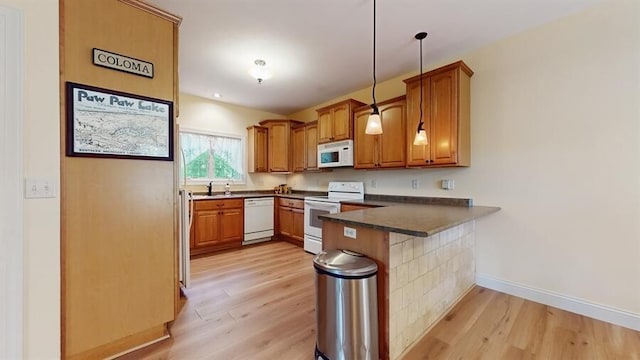 5026 Weatherford Dr, Coloma, MI 49038 - kitchen featuring white appliances, a peninsula, light wood-style floors, dark countertops, and brown cabinetry