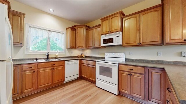 5026 Weatherford Dr, Coloma, MI 49038 - kitchen featuring white appliances, light wood-style floors, brown cabinetry, recessed lighting, and dark countertops