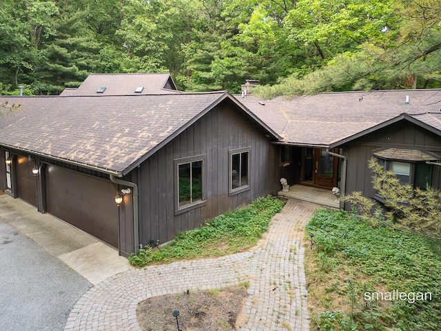 550 Greentree Ln NE, Ada, MI 49301 - view of front of house with roof with shingles, board and batten siding, and a forest view