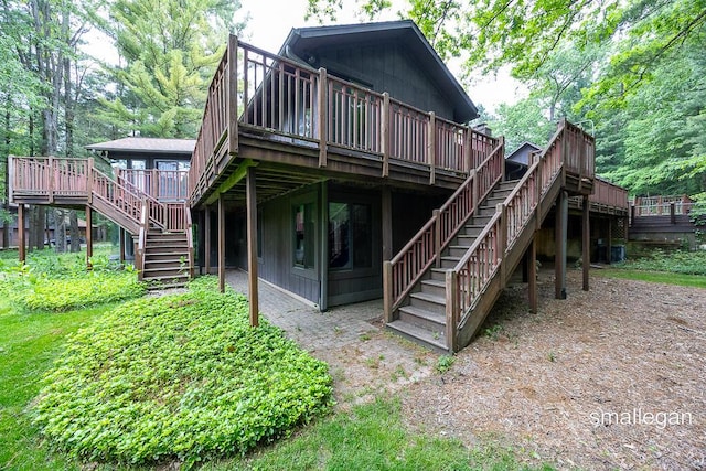550 Greentree Ln NE, Ada, MI 49301 - rear view of house with stairway and a wooden deck