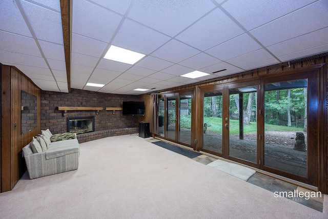 550 Greentree Ln NE, Ada, MI 49301 - carpeted living room featuring a paneled ceiling, a fireplace, and wooden walls