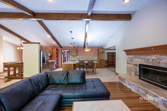 550 Greentree Ln NE, Ada, MI 49301 - living area with a textured ceiling, light wood-style flooring, a stone fireplace, and recessed lighting