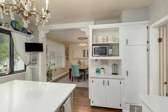 3155 24th Ave, Hudsonville, MI 49426 - kitchen featuring a chandelier, stainless steel microwave, light countertops, dark wood-type flooring, and decorative backsplash