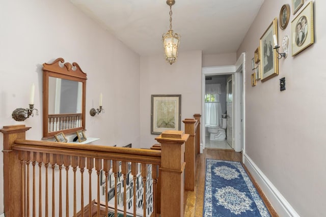 3155 24th Ave, Hudsonville, MI 49426 - corridor featuring wood finished floors, an upstairs landing, and a chandelier