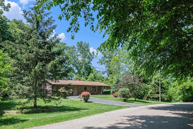 4104 Rurik Dr, Howell, MI 48843 - ranch-style house featuring a front lawn, driveway, and a chimney