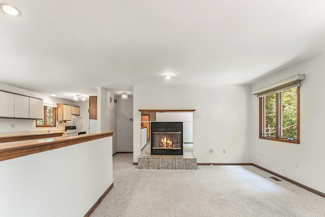 4104 Rurik Dr, Howell, MI 48843 - unfurnished living room with light colored carpet, plenty of natural light, a fireplace, and recessed lighting