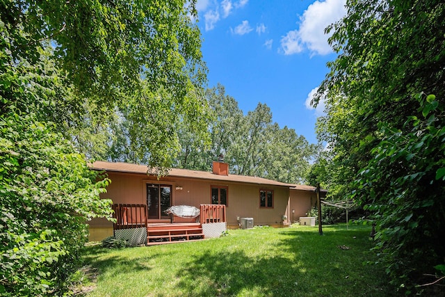 4104 Rurik Dr, Howell, MI 48843 - rear view of property with a lawn, a wooden deck, and a chimney