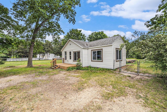 1694 S Mill Iron Rd, Muskegon, MI 49442 - rear view of house featuring a wooden deck, a shingled roof, and a gate