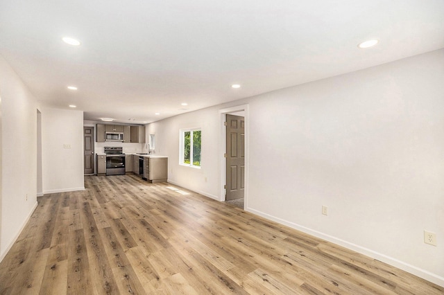 1694 S Mill Iron Rd, Muskegon, MI 49442 - unfurnished living room featuring recessed lighting and light wood-style floors