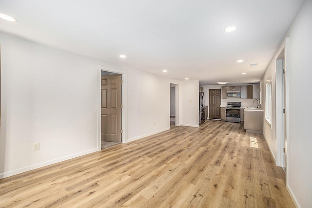 1694 S Mill Iron Rd, Muskegon, MI 49442 - unfurnished living room with light wood-style flooring and recessed lighting
