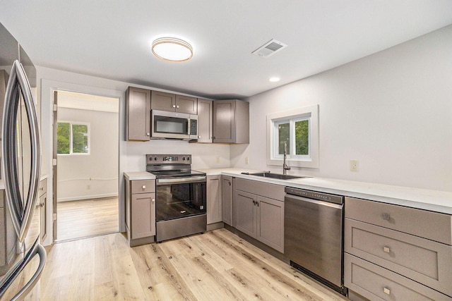 1694 S Mill Iron Rd, Muskegon, MI 49442 - kitchen featuring stainless steel appliances, gray cabinetry, light wood-style floors, light countertops, and recessed lighting
