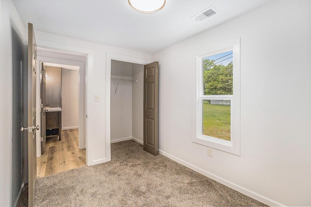 1694 S Mill Iron Rd, Muskegon, MI 49442 - unfurnished bedroom with light carpet and a closet
