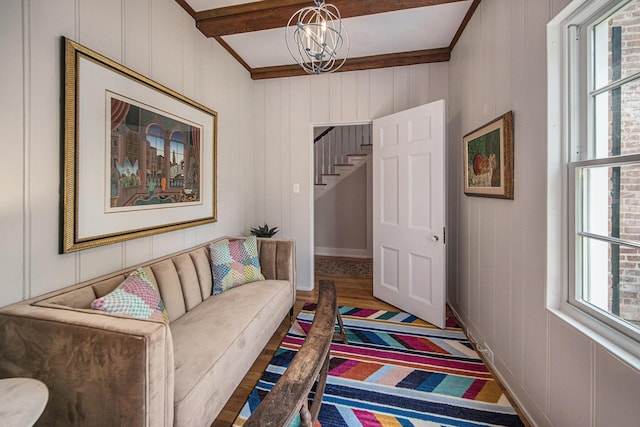 809 Berkshire Rd, Ann Arbor, MI 48104 - living area featuring beam ceiling, a chandelier, wood finished floors, stairs, and a decorative wall
