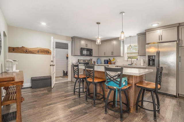 6710 28th Ave, Hudsonville, MI 49426 - kitchen featuring black microwave, stainless steel fridge, gray cabinets, light countertops, and dark wood-style flooring