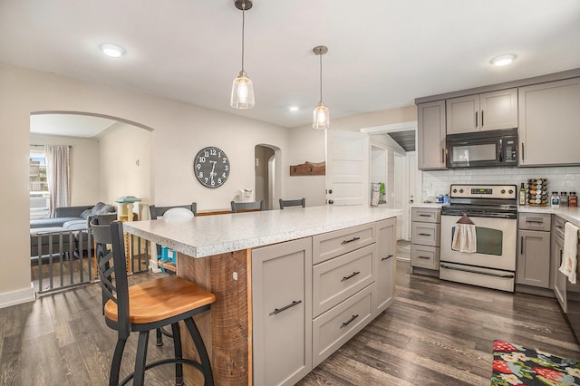 6710 28th Ave, Hudsonville, MI 49426 - kitchen with black microwave, stainless steel range with electric cooktop, arched walkways, and gray cabinetry