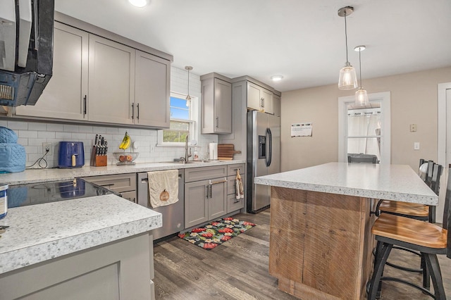 6710 28th Ave, Hudsonville, MI 49426 - kitchen featuring appliances with stainless steel finishes, gray cabinetry, dark wood-style flooring, decorative backsplash, and light countertops