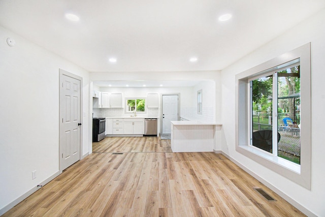 410 Warren Ave, Charlotte, MI 48813 - unfurnished living room with plenty of natural light, light wood finished floors, and recessed lighting