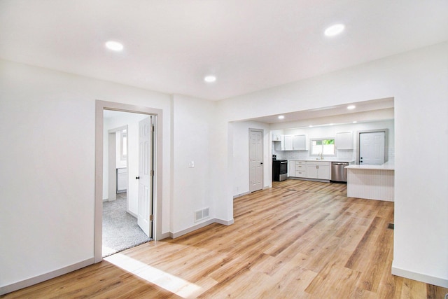 410 Warren Ave, Charlotte, MI 48813 - unfurnished living room featuring light wood-type flooring and recessed lighting