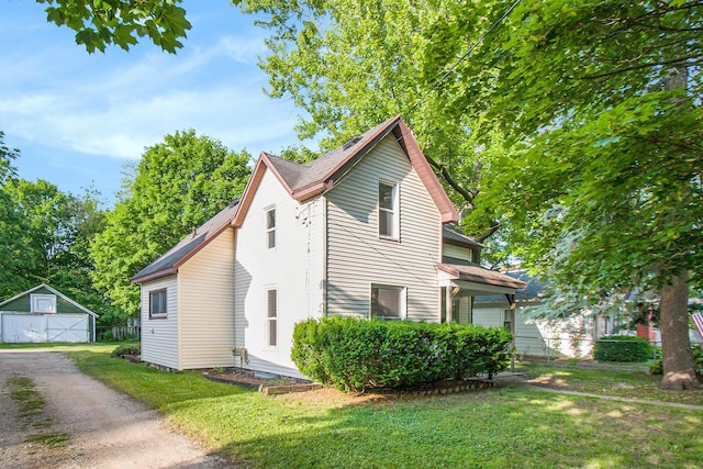 410 Warren Ave, Charlotte, MI 48813 - view of front of property featuring an outbuilding, a detached garage, dirt driveway, and roof with shingles