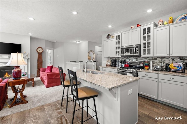 4441 Koinonia Dr NE Unit 3, Grand Rapids, MI 49525 - kitchen with stainless steel appliances, open floor plan, a kitchen island with sink, a breakfast bar, and decorative backsplash