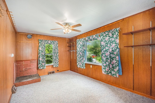 246 Ridgeway Rd, Jackson, MI 49202 - empty room featuring wooden walls, a ceiling fan, and carpet flooring