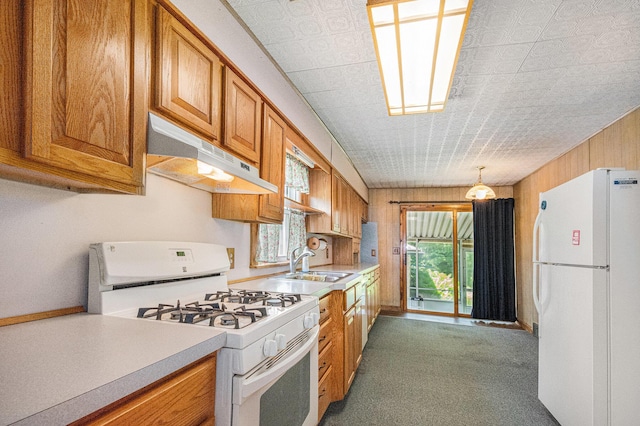 246 Ridgeway Rd, Jackson, MI 49202 - kitchen featuring white appliances, under cabinet range hood, brown cabinetry, light countertops, and wood walls