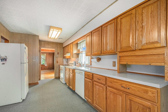 246 Ridgeway Rd, Jackson, MI 49202 - kitchen featuring white appliances, light countertops, brown cabinetry, and under cabinet range hood