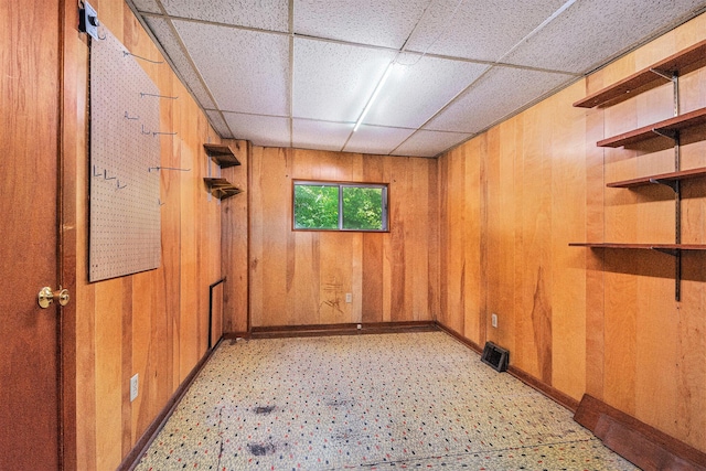 246 Ridgeway Rd, Jackson, MI 49202 - unfurnished room with a drop ceiling, wood walls, and light floors