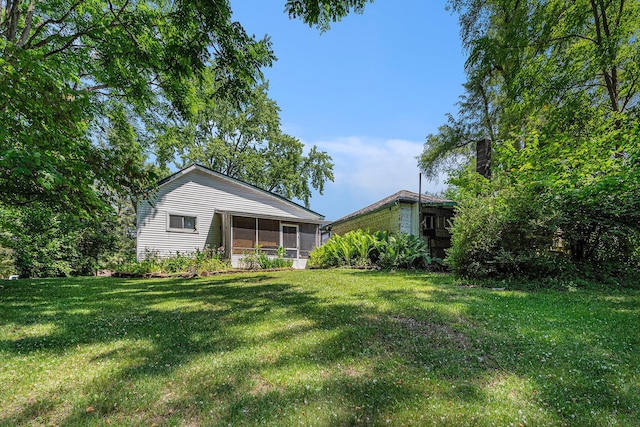 246 Ridgeway Rd, Jackson, MI 49202 - rear view of property with a sunroom and a lawn