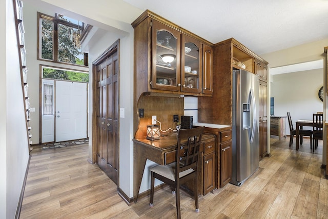 1863 Sunvale Dr SW, Wyoming, MI 49519 - kitchen featuring stainless steel refrigerator with ice dispenser, light wood-style floors, and glass insert cabinets