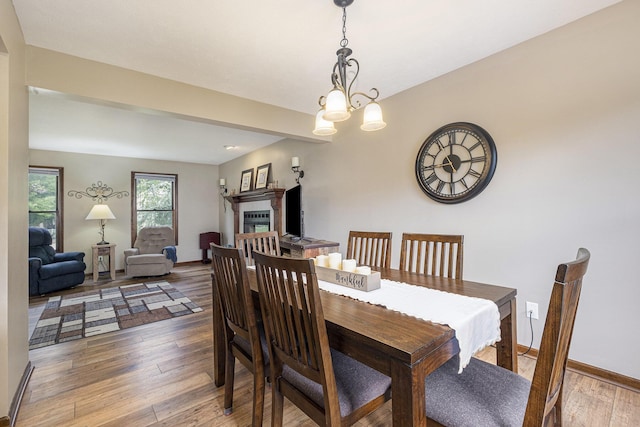 1863 Sunvale Dr SW, Wyoming, MI 49519 - dining area with wood-type flooring, a fireplace, and a chandelier