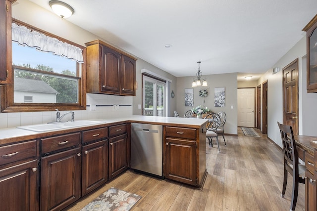 1863 Sunvale Dr SW, Wyoming, MI 49519 - kitchen with stainless steel dishwasher, light wood finished floors, light countertops, a peninsula, and a chandelier
