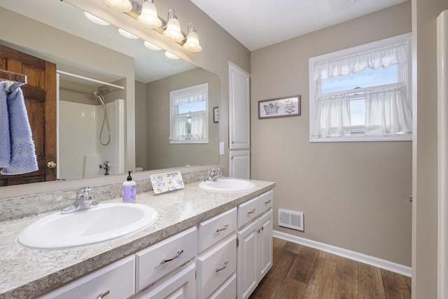 1863 Sunvale Dr SW, Wyoming, MI 49519 - full bathroom with a shower, double vanity, healthy amount of natural light, and wood finished floors