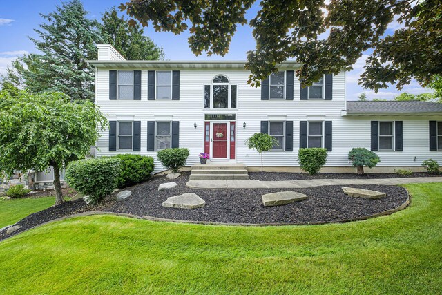 1863 Sunvale Dr SW, Wyoming, MI 49519 - colonial-style house with a front yard and a chimney