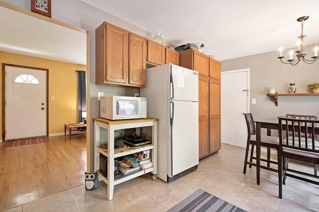 8683 Hemlock Ct, Ypsilanti, MI 48198 - kitchen featuring white appliances, a chandelier, light tile patterned floors, pendant lighting, and brown cabinets