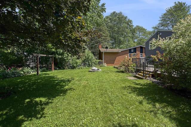 8683 Hemlock Ct, Ypsilanti, MI 48198 - view of green lawn with an outdoor fire pit
