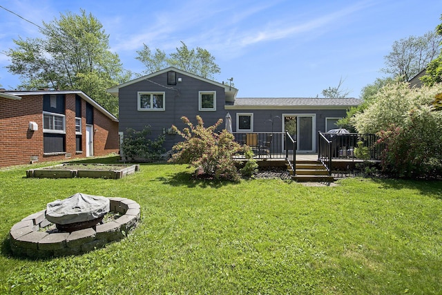 8683 Hemlock Ct, Ypsilanti, MI 48198 - rear view of house featuring a fire pit, a yard, and a deck