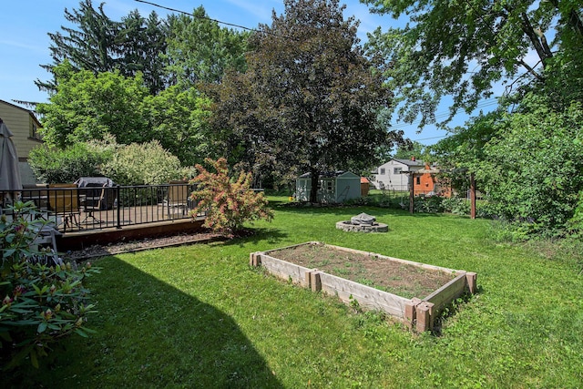 8683 Hemlock Ct, Ypsilanti, MI 48198 - view of yard featuring a storage shed, a wooden deck, and a fire pit