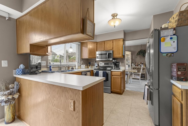 24663 Balsam Ct, Flat Rock, MI 48134 - kitchen featuring stainless steel appliances, a peninsula, light countertops, and brown cabinets