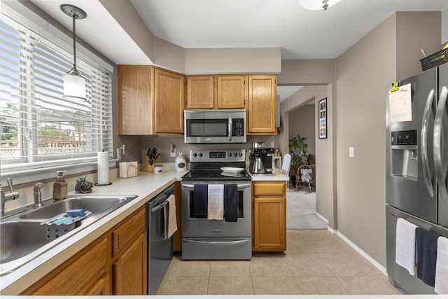 24663 Balsam Ct, Flat Rock, MI 48134 - kitchen featuring stainless steel appliances, light countertops, light tile patterned floors, pendant lighting, and brown cabinetry