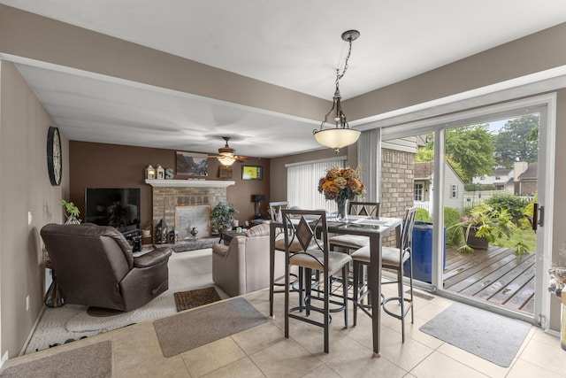24663 Balsam Ct, Flat Rock, MI 48134 - dining room featuring a ceiling fan, a brick fireplace, and light tile patterned floors