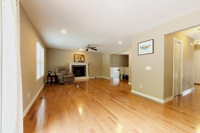 1481 Kristen Path, Saint Joseph, MI 49085 - unfurnished living room with light wood-style flooring, ceiling fan, a glass covered fireplace, and recessed lighting