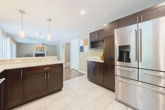 1481 Kristen Path, Saint Joseph, MI 49085 - kitchen featuring high quality fridge, dark brown cabinets, a fireplace, hanging light fixtures, and recessed lighting